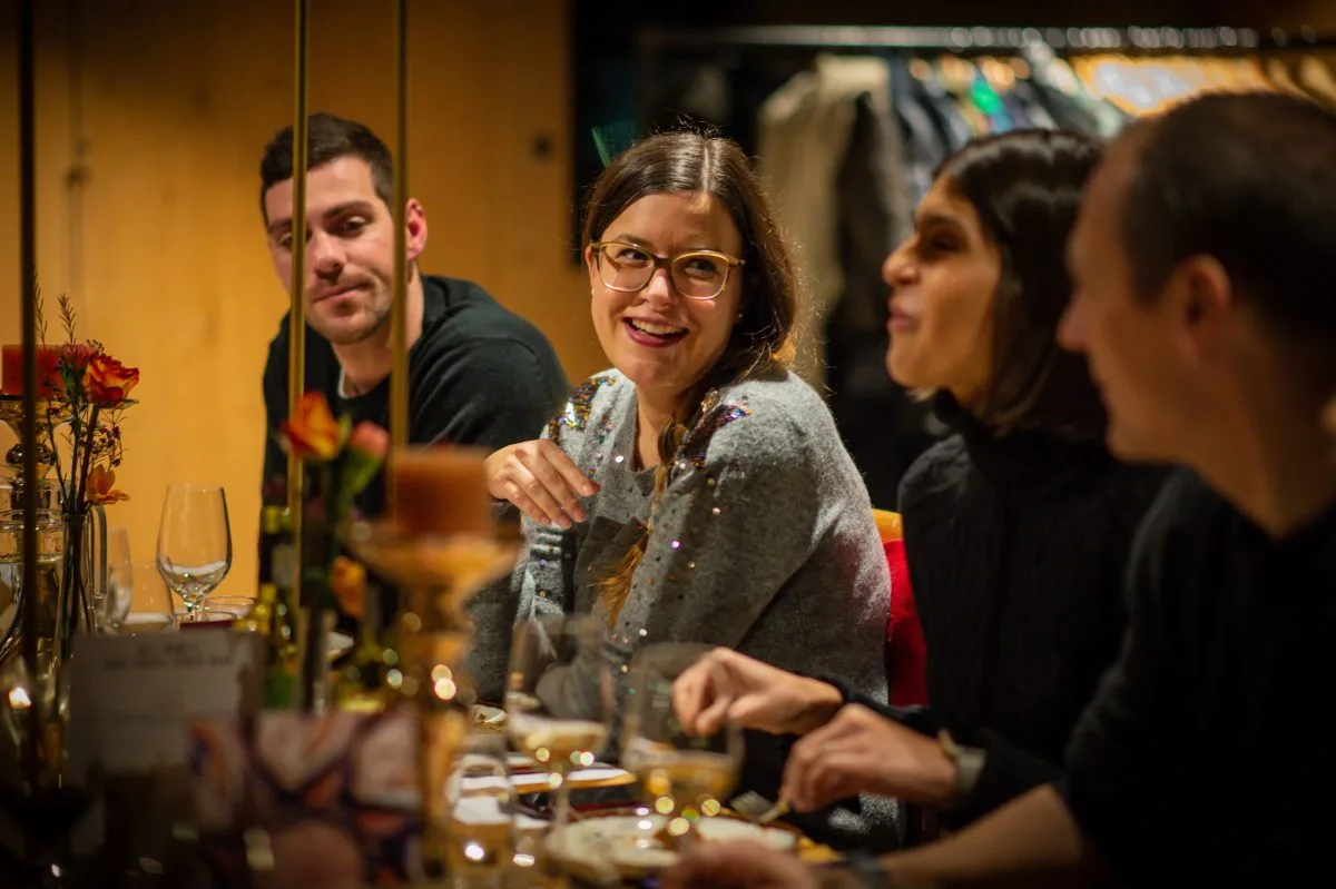 Menschen lachen gemeinsam an einem Tisch